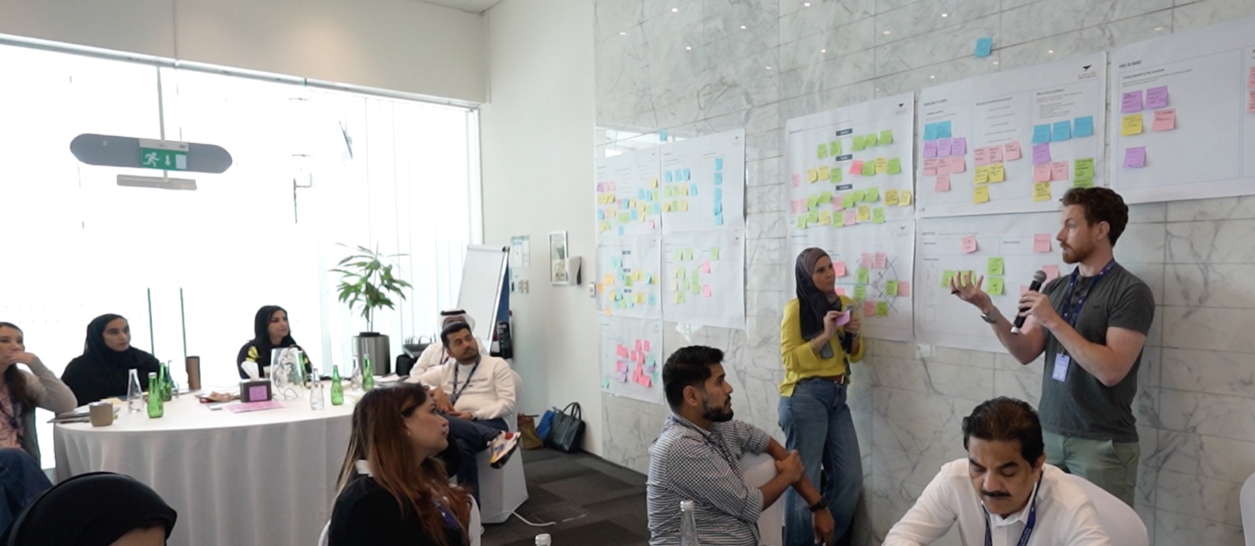 Garry facilitating a collaborative experience design workshop in front of journey maps and participant research